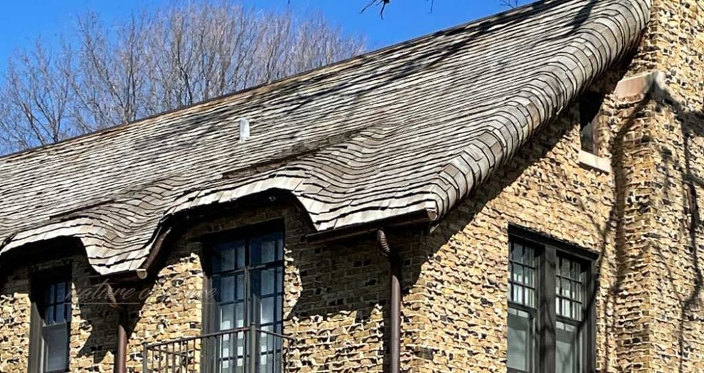 Steam Bent Cedar Shingles 4 side of house with steamed cedar bent shingles with brick siding and dark windows