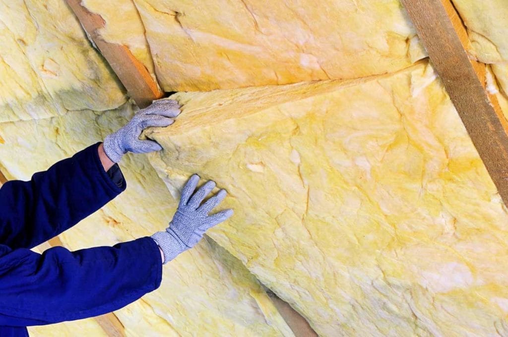 Insulating an Attic: Benefits, How-to & Tips 4 installing fiberalls batt insulation in an attic