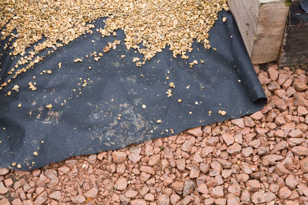 In-Depth Guide: Pea Gravel Patio Pros & Cons 4 weed barrier fabric on crushed stone for pea gravel patio