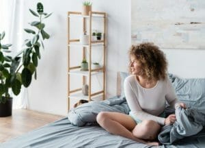 4 Best Bedroom Plants: Purify Air, Improve Sleep & Add Decor 1 woman with bedroom plants.