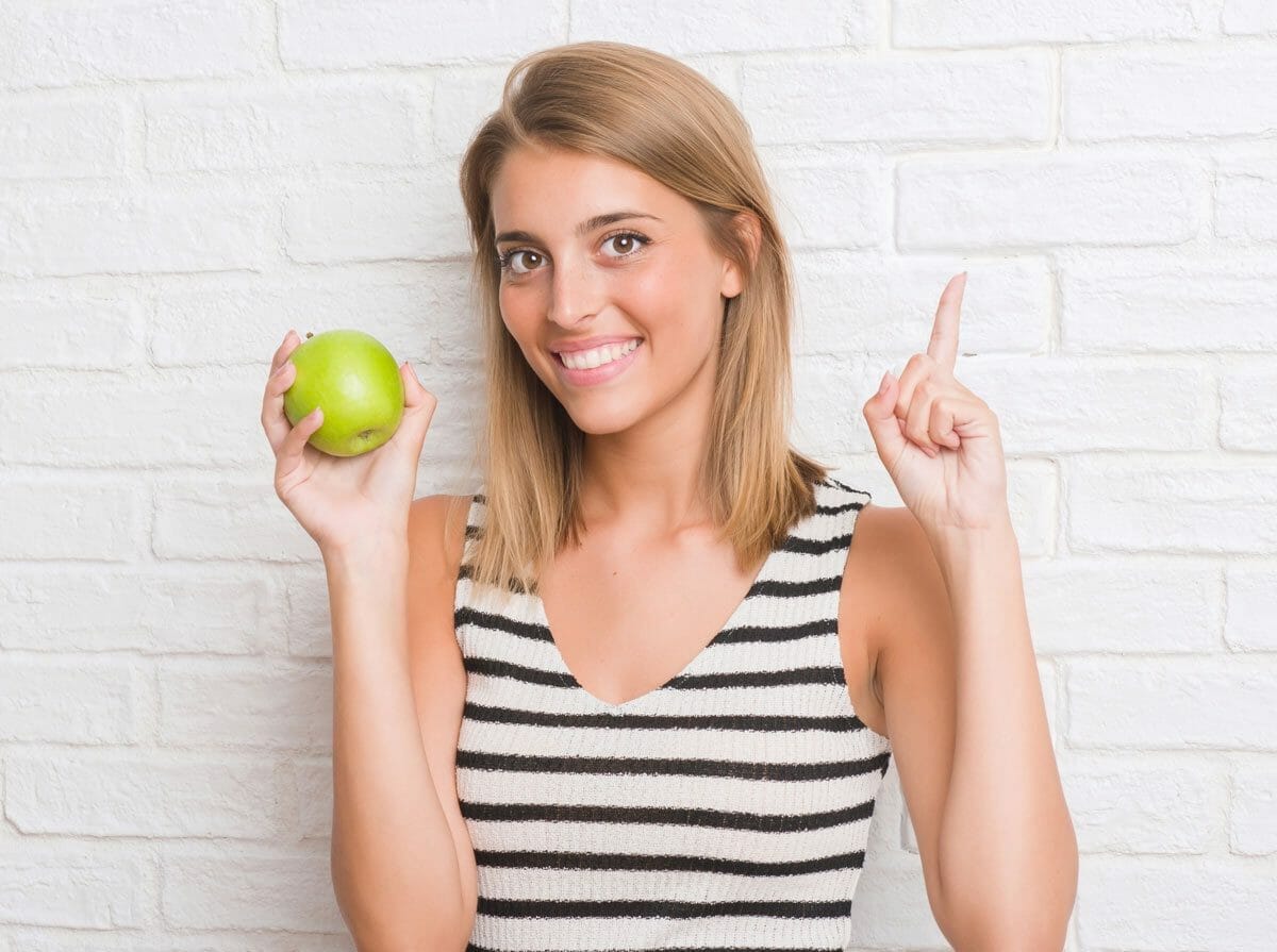 10 Delicious Fruits and Vegetables That Are Surprisingly Man-Made 3 woman with apple