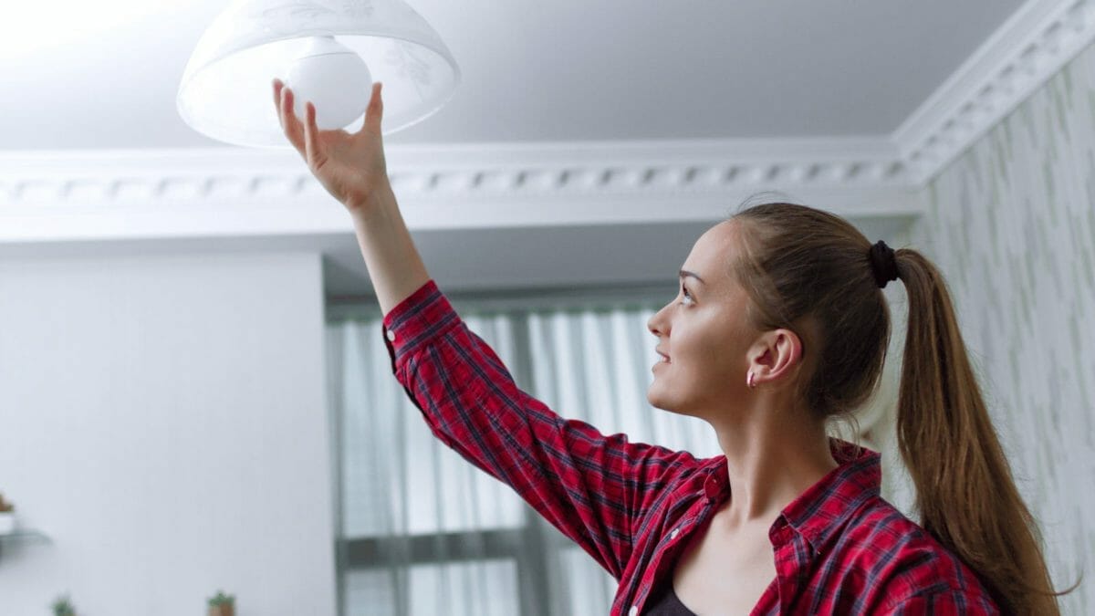 15 Electrician-Approved Ways to Improve Home Safety & Cut Energy Costs 16 woman changing a light bulb
