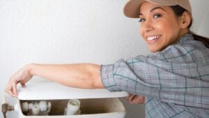 Easy Fix for a Weak Toilet Flush: Adjusting the Chain Length 1 woman fixing a toilet with a weak flush