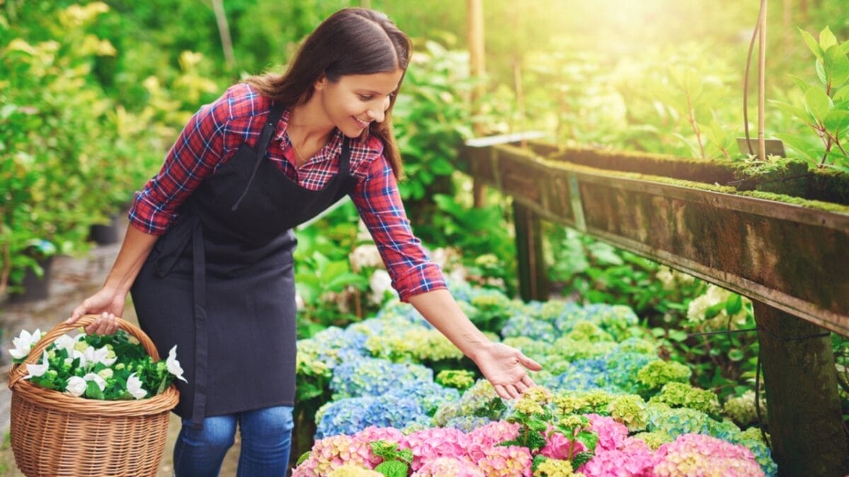 7 Tips to Keep Your Flowerbeds Pristine 9 7 Tips to Keep Your Flowerbeds Pristine - happy woman in flower garden ss403288711