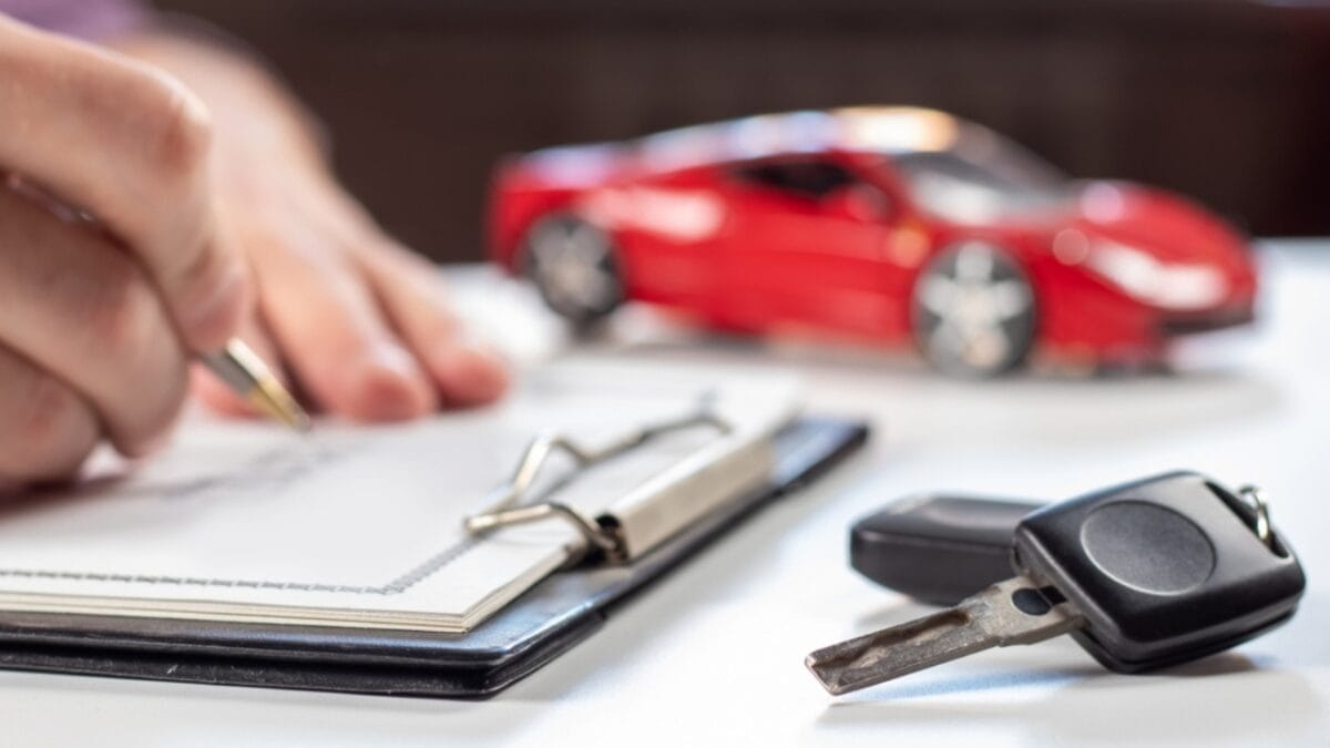 Thinking of Buying an EV? Watch Out for These 10 Hidden Fees 5 Thinking of Buying an EV? Watch Out for These 10 Hidden Fees - man signing document car insurance keys ss2277715709