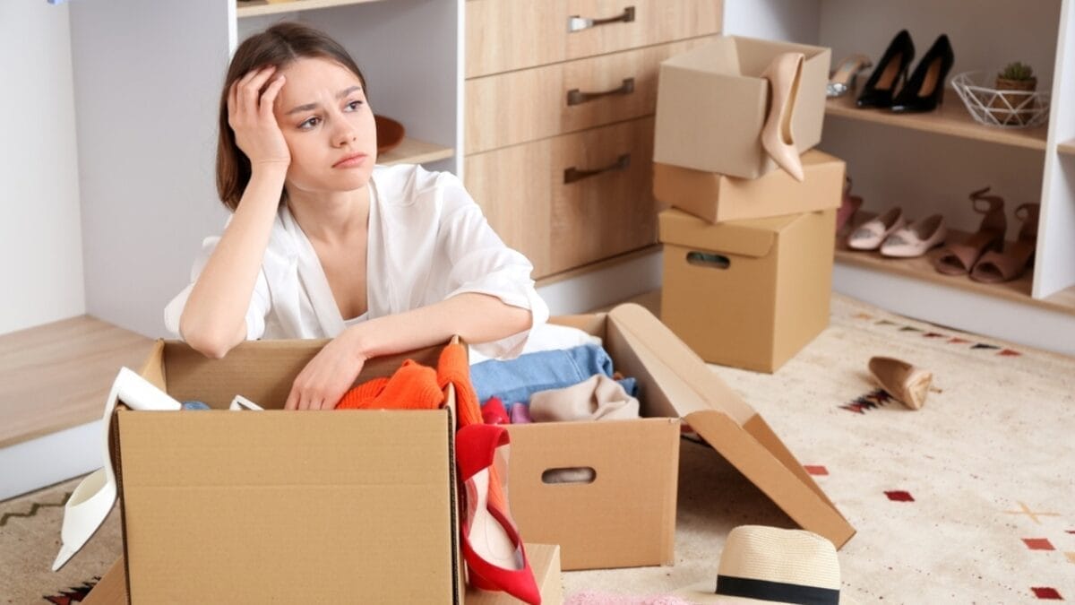 The 12-12-12 Decluttering Challenge Is Your Path to a Tidier Home 4 The 12-12-12 Decluttering Challenge Is Your Path to a Tidier Home - upset woman with boxes wardrobe ss2108238155
