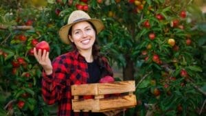 16 Fast Growing Fruit Trees for Impatient Gardeners 1 16 Fast Growing Fruit Trees for Impatient Gardeners - woman holding apple dp618826066