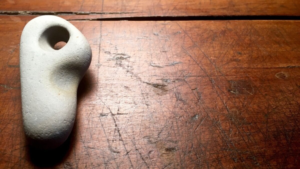 7 Stress-Busting Benefits of Worry Stones to Help Calm Your Mind - stone on wood ss561753541
