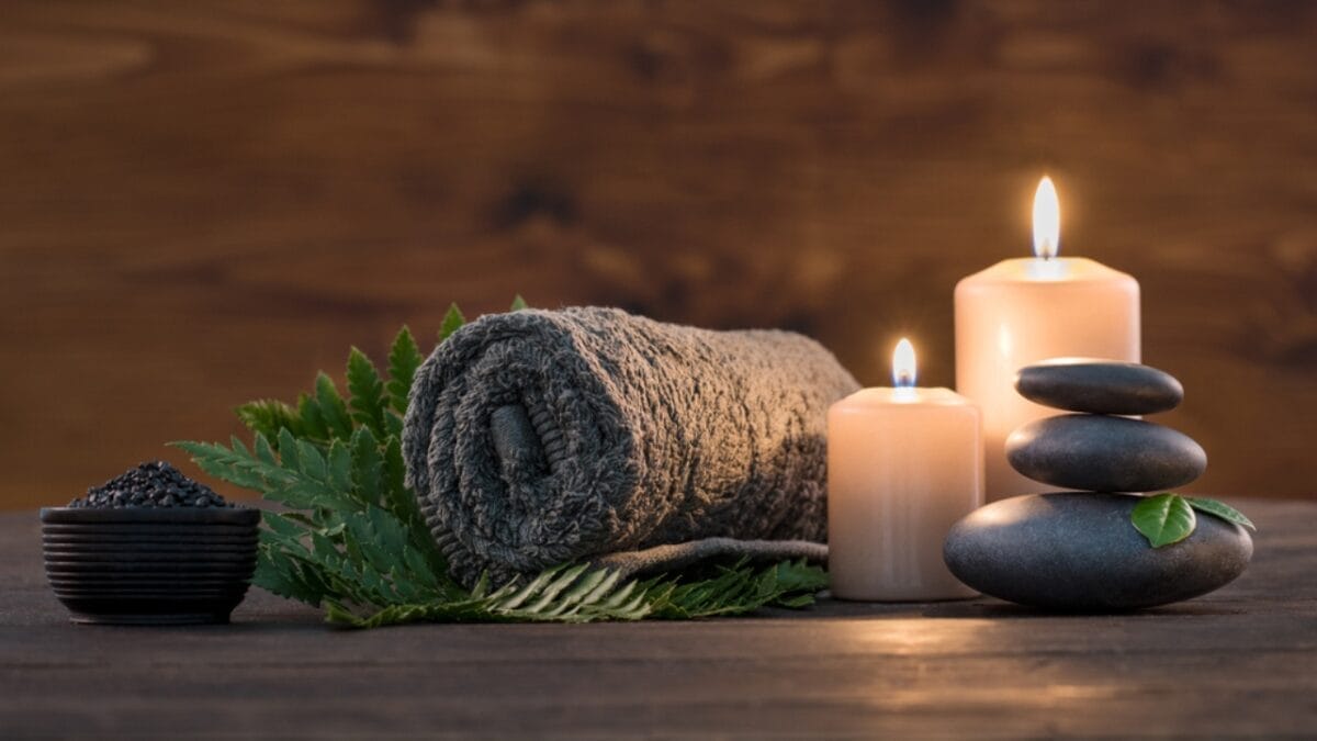 7 Stress-Busting Benefits of Worry Stones to Help Calm Your Mind 7 7 Stress-Busting Benefits of Worry Stones to Help Calm Your Mind - towel with massaging stone candle ss732336370