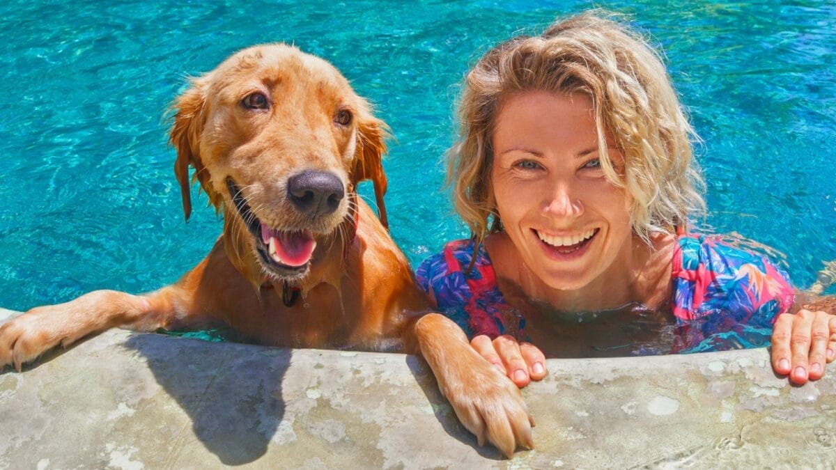 20 Unforgettable Experiences for Your Dog's Bucket List 13 20 Unforgettable Experiences for Your Dog's Bucket List - woman dog swimming ss420634483