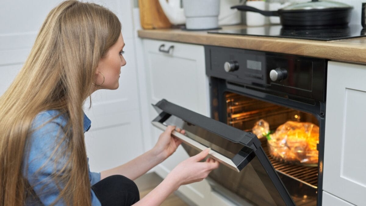 This Chicken Recipe Is So Good, It Might Just Get You a Proposal - woman cooking with oven ss1935204746