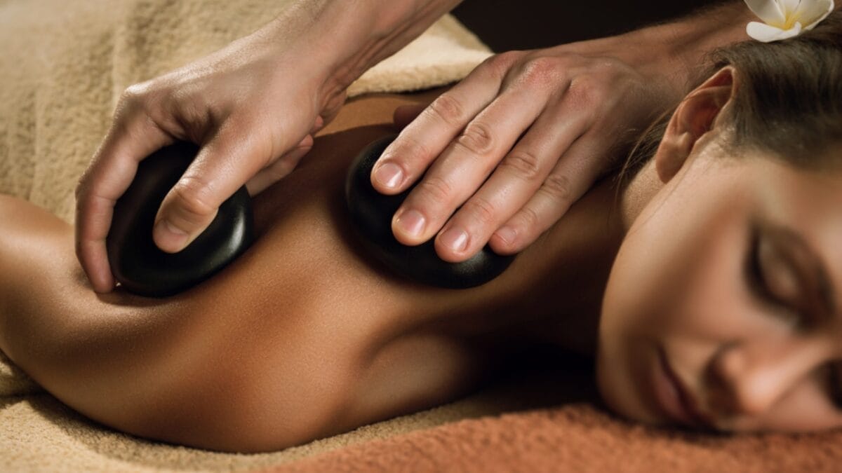 7 Stress-Busting Benefits of Worry Stones to Help Calm Your Mind - woman massaging stone ss399976321