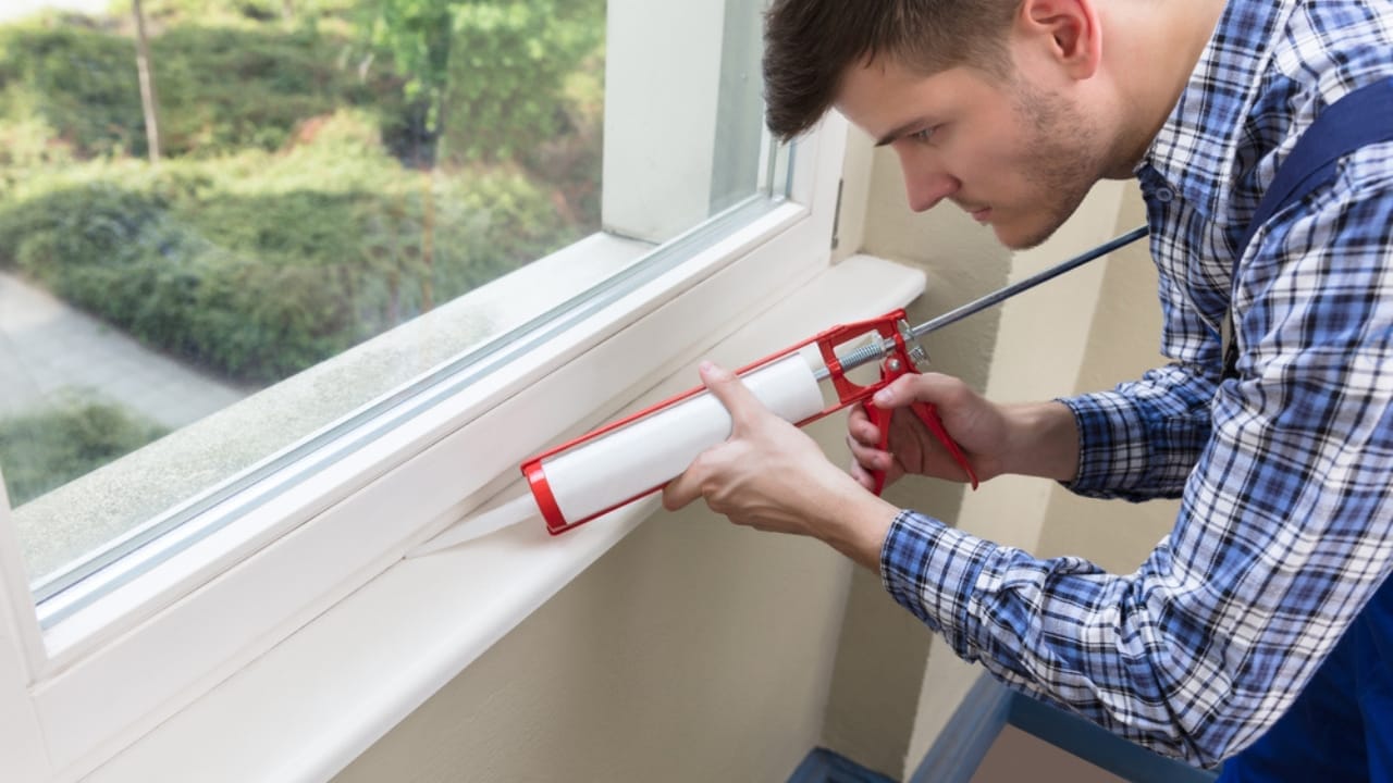 8 Ways Experts Insulate Windows and Doors Before a Freeze—and Why You Should Too - applying silicone on window dp161933928