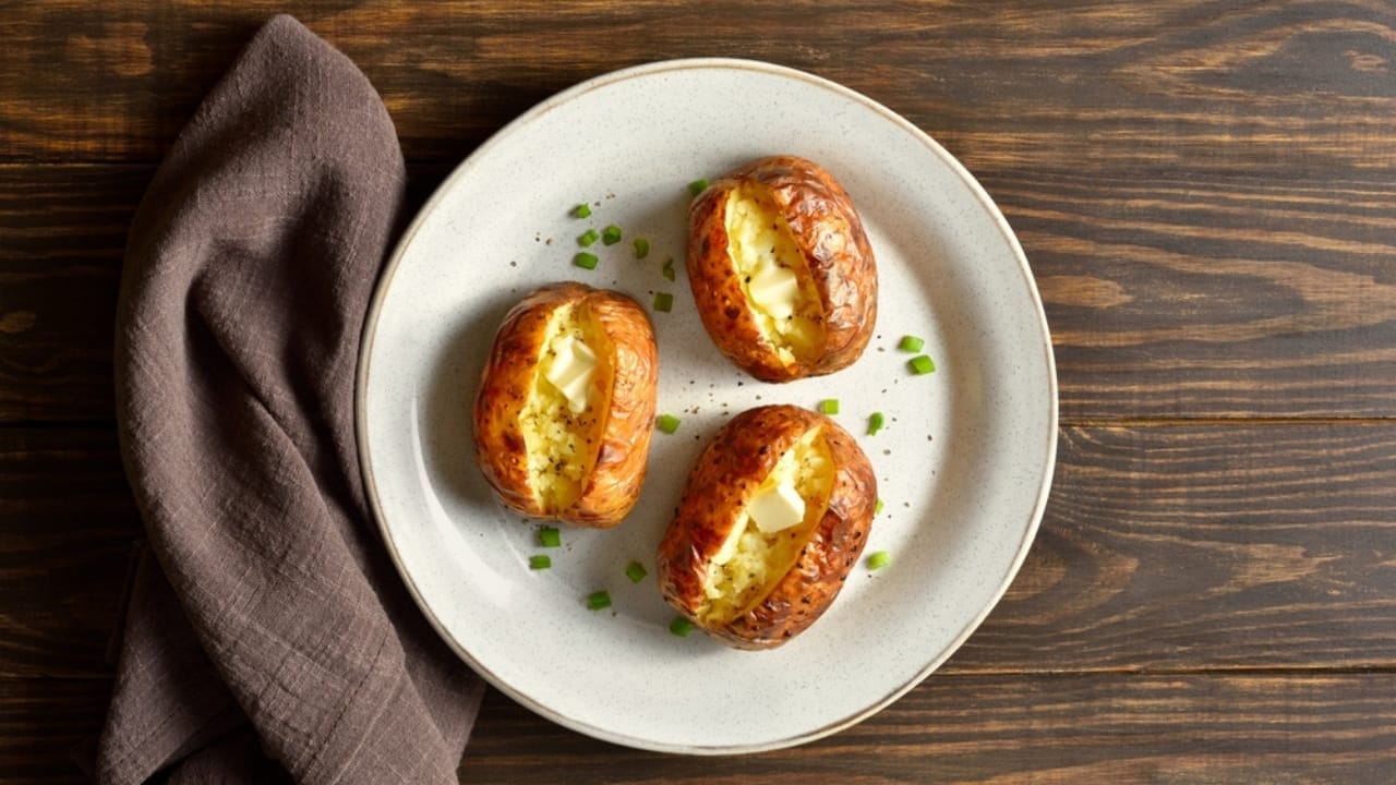 10 Tips for Baking Potatoes Like a Pro—And a Microwave Method When You’re in a Pinch 12 10 Tips for Baking Potatoes Like a Pro—And a Microwave Method When You’re in a Pinch - baked potato with butter ss2483381361
