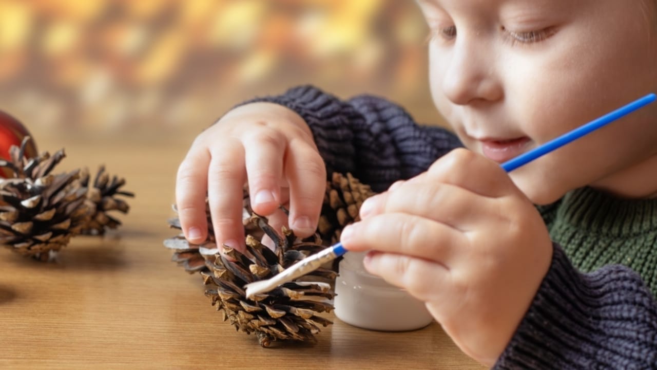 10 Creative Ways to Use Pine Cones in Your Home & Garden 11 10 Creative Ways to Use Pine Cones in Your Home & Garden - child paints pine cone decoration for christmas ss2378265349