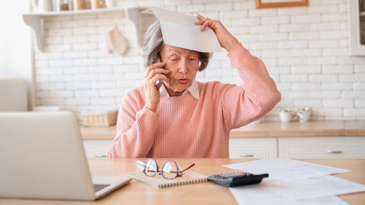 12 Reasons Why Homeowners & Renters Deem HOAs as Bad News - senior woman taxes papers ss 2411089077