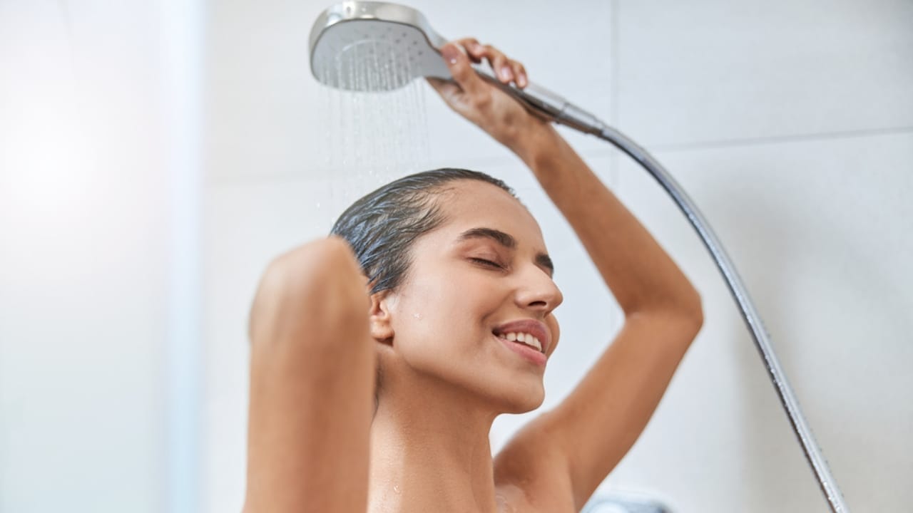 10 Indulgent Items for a Truly Luxurious Shower Experience - woman showering using Handheld Showerhead ss1824897836