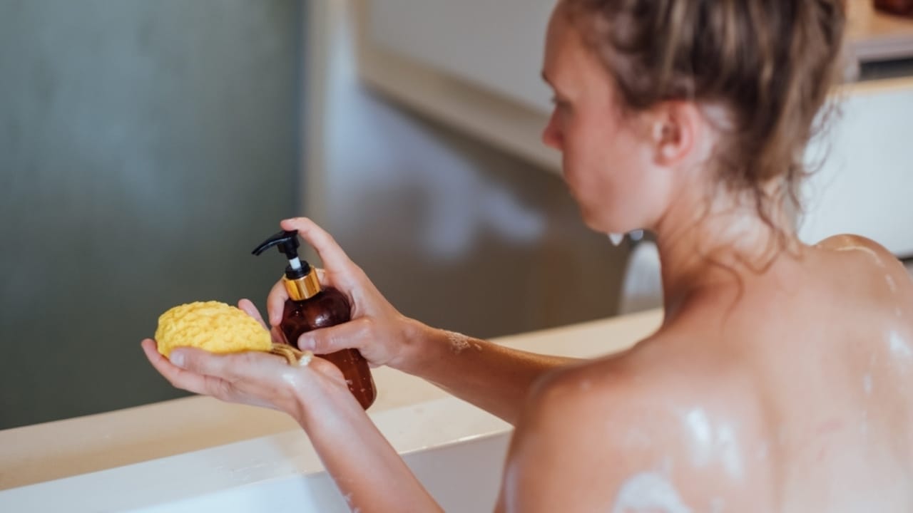 10 Indulgent Items for a Truly Luxurious Shower Experience - woman using shower gel and body scrub ss2415841051