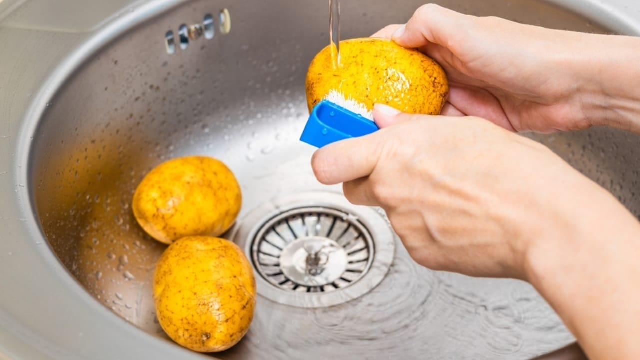 10 Tips for Baking Potatoes Like a Pro—And a Microwave Method When You’re in a Pinch 4 10 Tips for Baking Potatoes Like a Pro—And a Microwave Method When You’re in a Pinch - woman washing potato ss2494411765