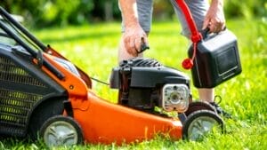 Old Lawnmower Gas— Here’s How to Safely Get Rid of It 1 Old Lawnmower Gas— Here’s How to Safely Get Rid of It - Man pouring fuel in lawn mower dp391634170