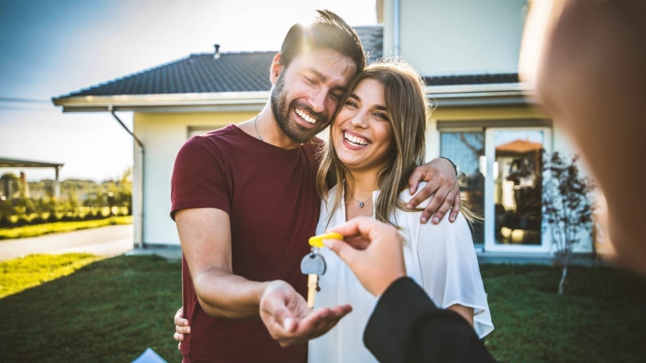 Homeownership Dreams Collide: Boomers’ Views vs. Millennials’ Reality - couple receiving keys of house from realtor ss2234397689
