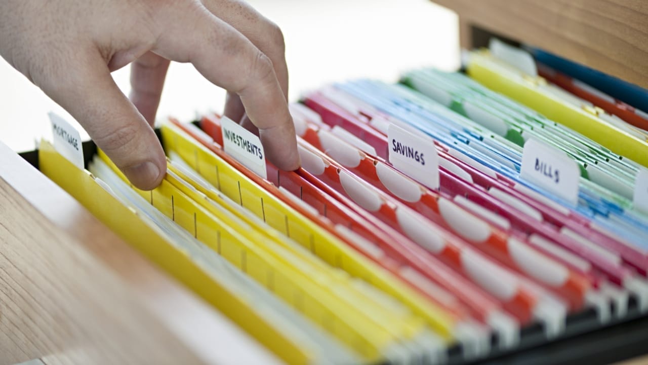 Declutter Your Home in a Flash with These 18 Everyday Items 20 Declutter Your Home in a Flash with These 18 Everyday Items - hand searching through file folder ss136964447