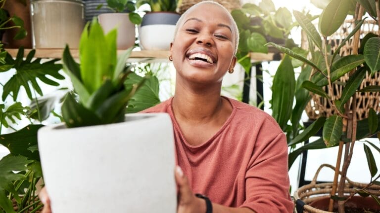 Attract Positive Energy: 15 Good Luck Plants for Your Home 3 Attract Positive Energy: 15 Good Luck Plants for Your Home - happy woman houseplant ss2327421215