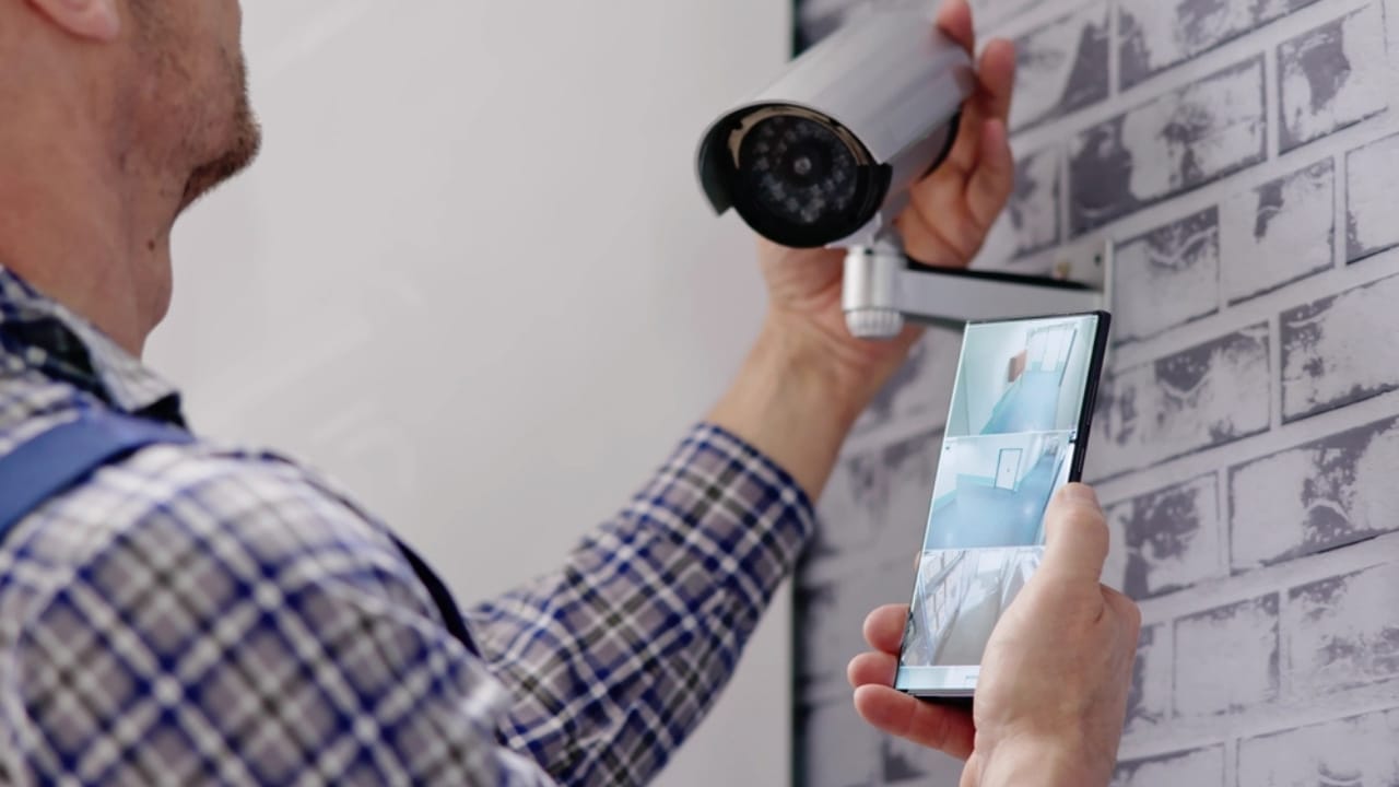 Turn Your Dusty Old Smartphone into a Home Security System 5 Turn Your Dusty Old Smartphone into a Home Security System - man checking security camera on smart phone ss2454788051