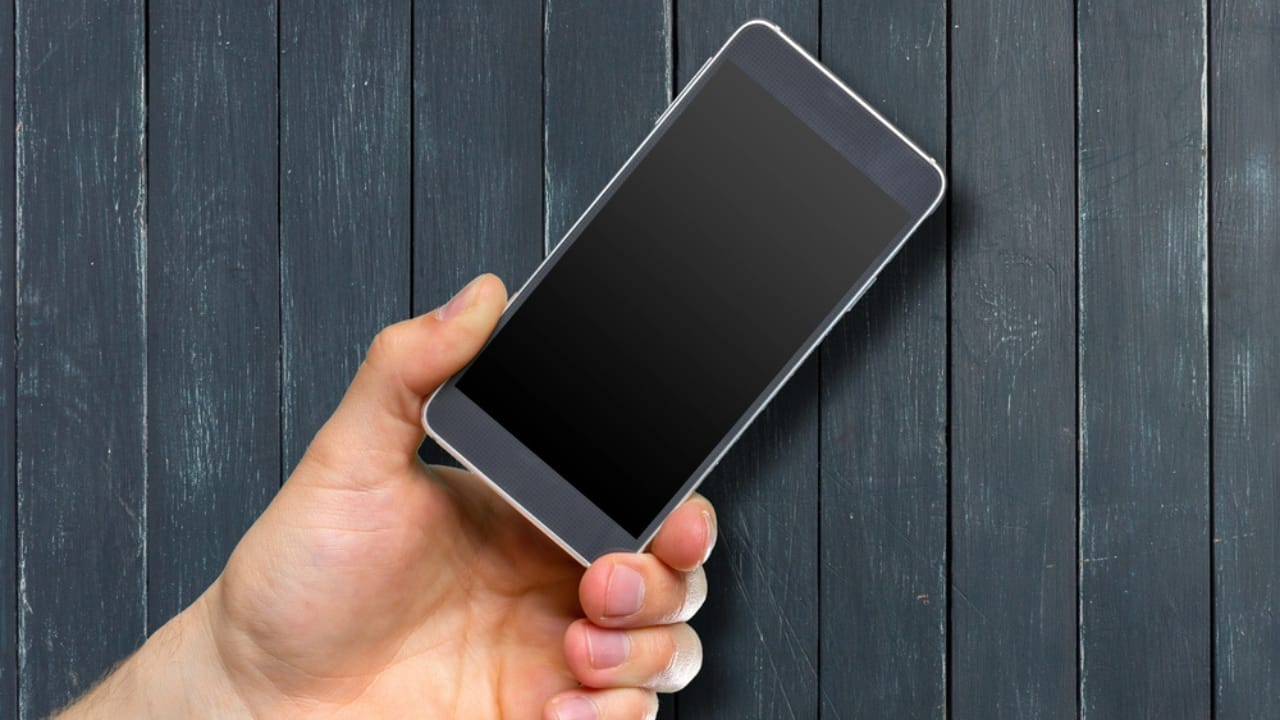 Turn Your Dusty Old Smartphone into a Home Security System 2 Turn Your Dusty Old Smartphone into a Home Security System - man hand holding smartphone dp220230038