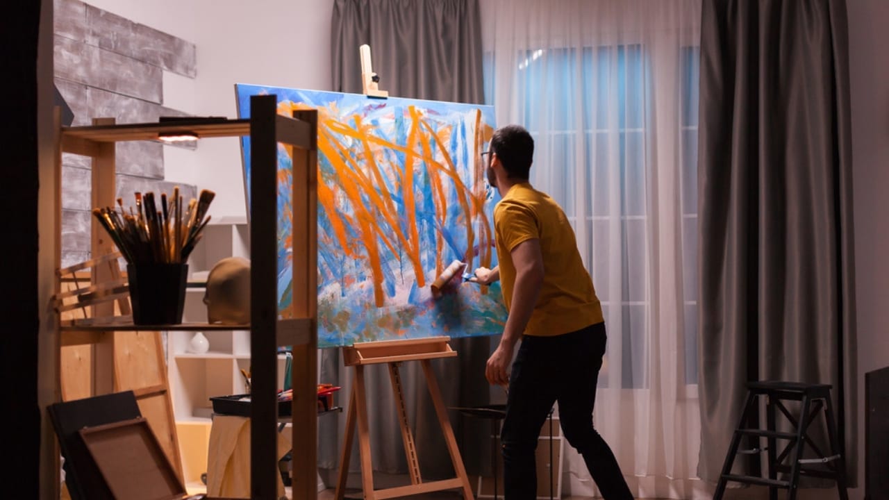 6 Art-Hanging Mistakes to Avoid for Perfectly Balanced Walls 3 6 Art-Hanging Mistakes to Avoid for Perfectly Balanced Walls - man painting dp404546708