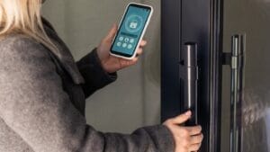 Turn Your Dusty Old Smartphone into a Home Security System 1 Turn Your Dusty Old Smartphone into a Home Security System - woman holding smart phone with home application screen ss2466859989