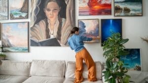 6 Art-Hanging Mistakes to Avoid for Perfectly Balanced Walls 1 6 Art-Hanging Mistakes to Avoid for Perfectly Balanced Walls - woman painter ss2465399493