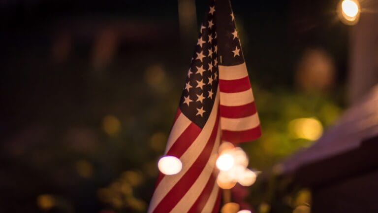 Old Glory in the Spotlight: 6 Tips for Illuminating Your Flagpole According to U.S. Guidelines - American flag in backyard at night ss668982307
