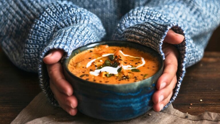 21 Hearty Protein-Packed Soups That Will Keep Your Tummy & Tastebuds Happy 7 21 Hearty Protein-Packed Soups That Will Keep Your Tummy & Tastebuds Happy - Female hands holding a bowl of pumpkin soup ss1192495123