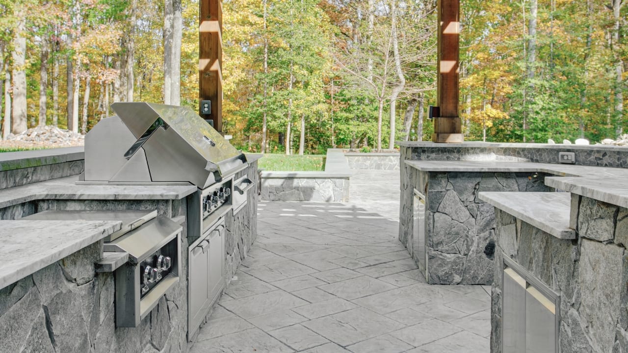 18 Fresh Patio Design Ideas to Elevate Your Outdoor Space in 2024 7 18 Fresh Patio Design Ideas to Elevate Your Outdoor Space in 2024 - Outdoor Patio with Large Stone Kitchen Island Grill and Seating Area ss2440400581 degm