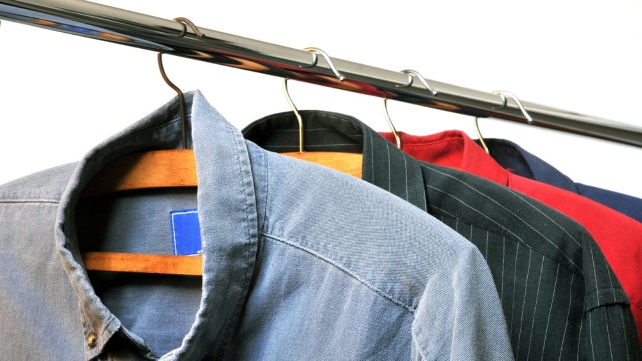 13 Clever Ways to Dry Clothes Indoors Without a Dryer - Shirts on hangers hanging on a rod dp350160068
