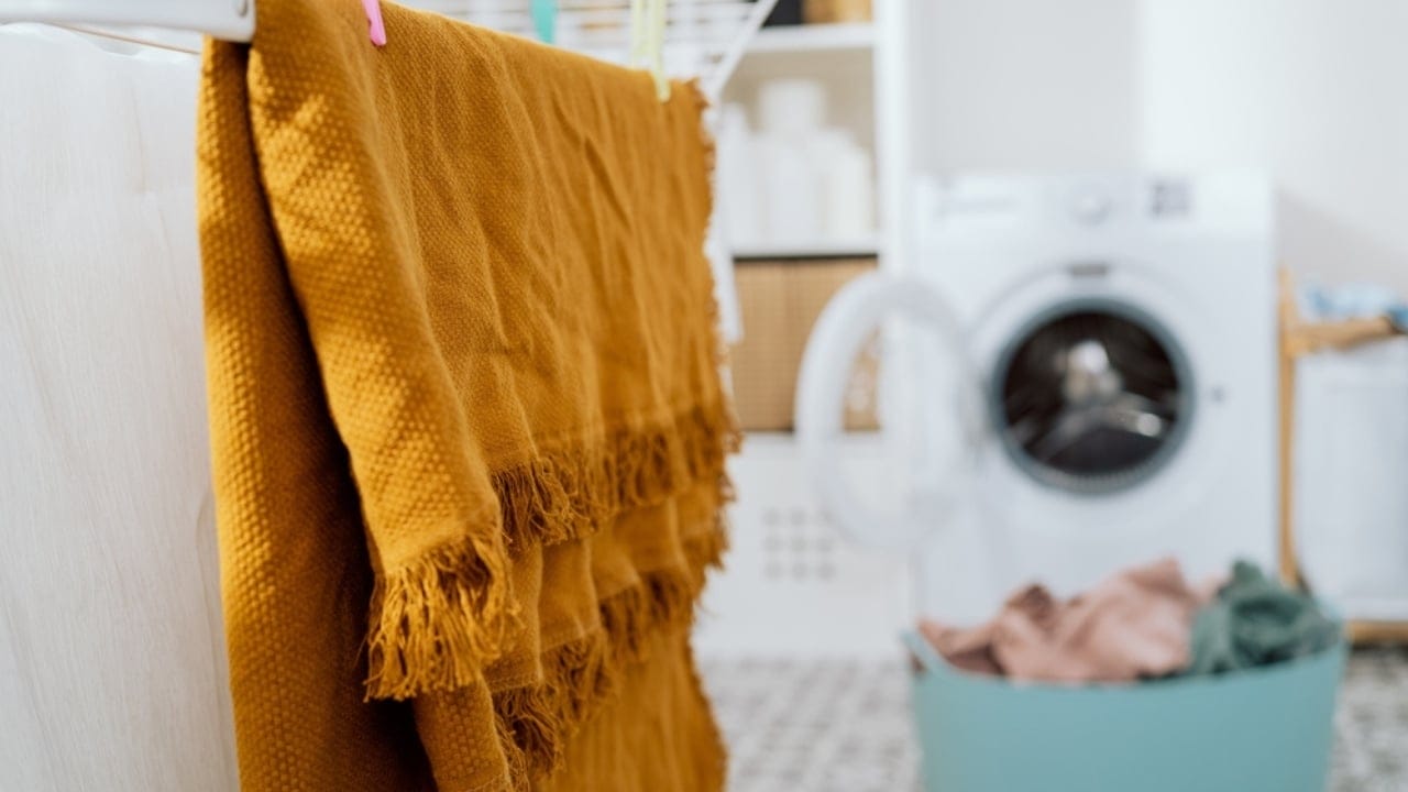 13 Clever Ways to Dry Clothes Indoors Without a Dryer - hanging towel laundry blanket ss2116796786