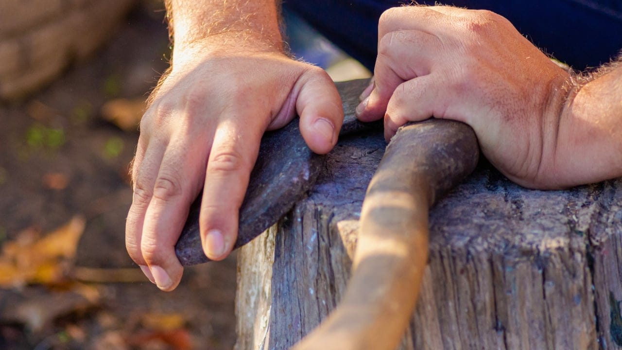 The Bushcrafter's Guide to Sharpening an Axe by Hand 3 The Bushcrafter's Guide to Sharpening an Axe by Hand - man sharpens an axe with a whetstone ss