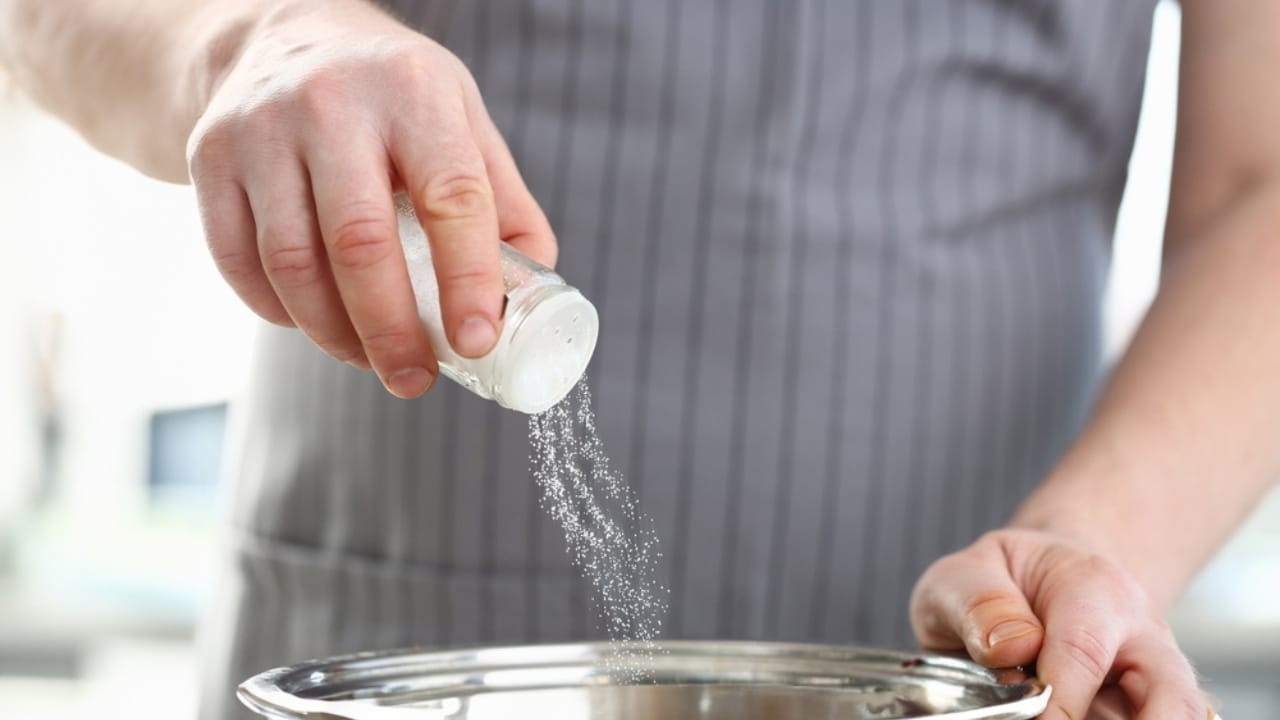15 Surprising Ways Salt Can Keep You Alive in Emergencies 9 15 Surprising Ways Salt Can Keep You Alive in Emergencies - man putting salt in pan ss2389561147