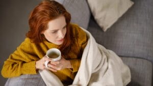 10 Key Home Details That Make Gilmorecore the Coziest Trend of the Season 1 10 Key Home Details That Make Gilmorecore the Coziest Trend of the Season - relaxed woman sitting dp137473232