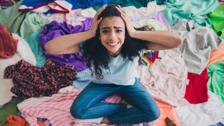 The Surprising Ways Clutter Hijacks Your Brain (and How to Take Back Control) 1 The Surprising Ways Clutter Hijacks Your Brain (and How to Take Back Control) - stressed woman messy clutter clothes ss2484953003