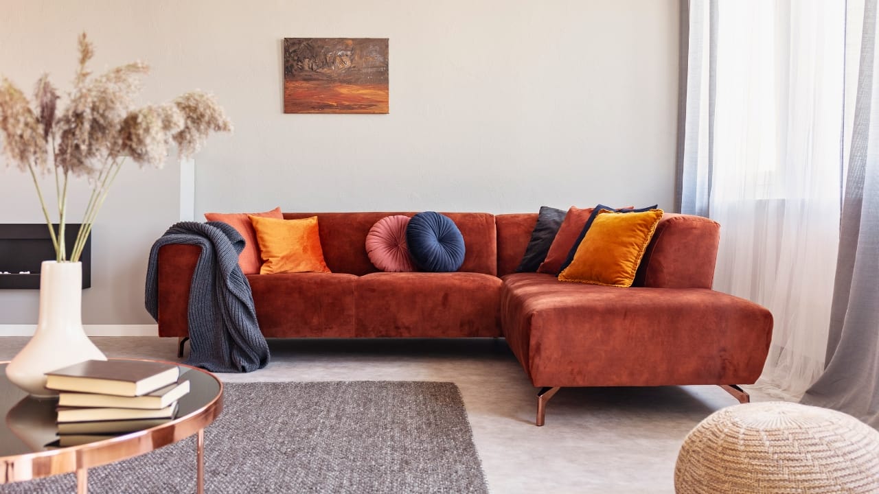 10 Key Home Details That Make Gilmorecore the Coziest Trend of the Season 10 10 Key Home Details That Make Gilmorecore the Coziest Trend of the Season - warm color cushions on a red couch ss1575588457 degm