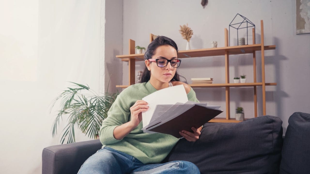 Stop Storing These 15 Things in the Bathroom—Here’s Why - woman holding documents dp502689860
