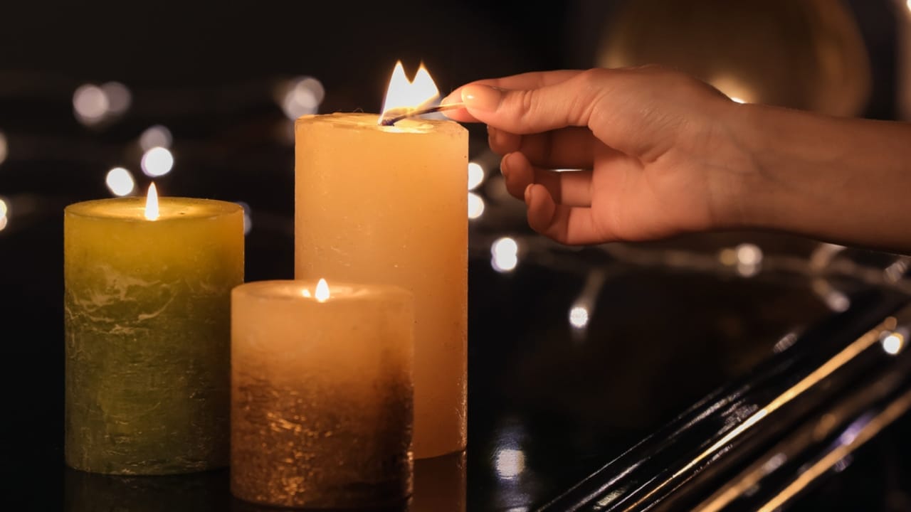 54% of Americans Face Disaster Risks: 18 Goodwill Essentials for Budget Survival Kits - woman lighting candles dp535021936