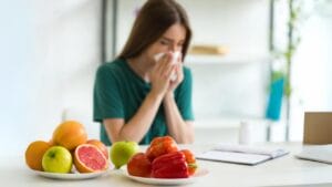 33 Superfoods to Strengthen Your Immunity & Keep You Feeling Your Best 1 33 Superfoods to Strengthen Your Immunity & Keep You Feeling Your Best - woman sitting at table with vegetables and fruits dp280447774