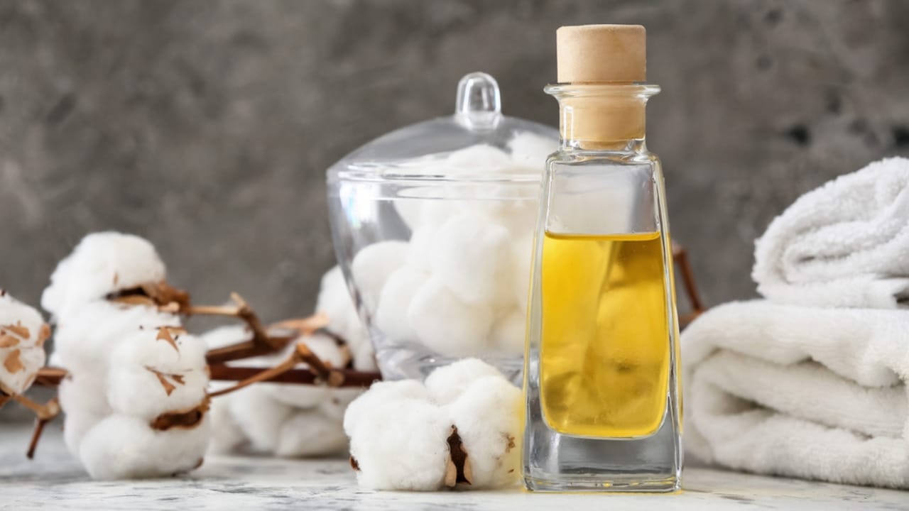 Make Your Bathroom Smell Amazing with This Cotton Ball Hack 4 Make Your Bathroom Smell Amazing with This Cotton Ball Hack - Bottle of essential cottonseed oil on table dp436598640 dnoh