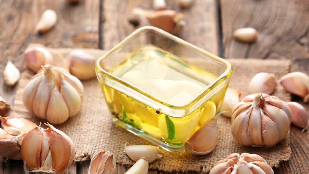 Make Your Own Healing Garlic Salve for Soothing Relief 6 Make Your Own Healing Garlic Salve for Soothing Relief - Bowl of garlic oil on wooden background dp463255746 dnoh