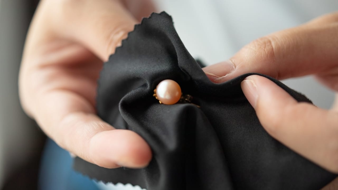 6 Tips to Make Your Jewelry Shine This Holiday Season 6 6 Tips to Make Your Jewelry Shine This Holiday Season - Jeweller cleaning jewelry pearl earrings ss2109263798 dpdgm