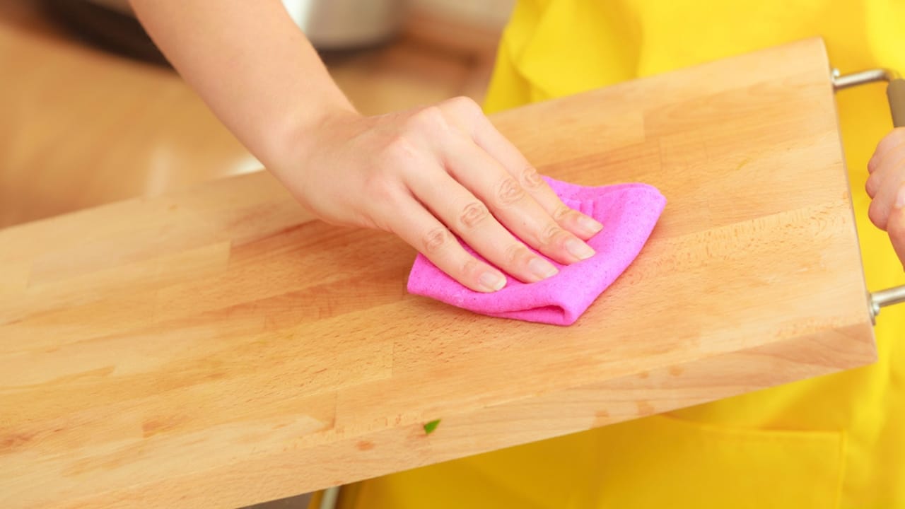 Ditch Mineral Oil: Make This Natural Butter for Your Cutting Board 3 Ditch Mineral Oil: Make This Natural Butter for Your Cutting Board - Woman cleaning wooden cutting board dp101625868 dnoh
