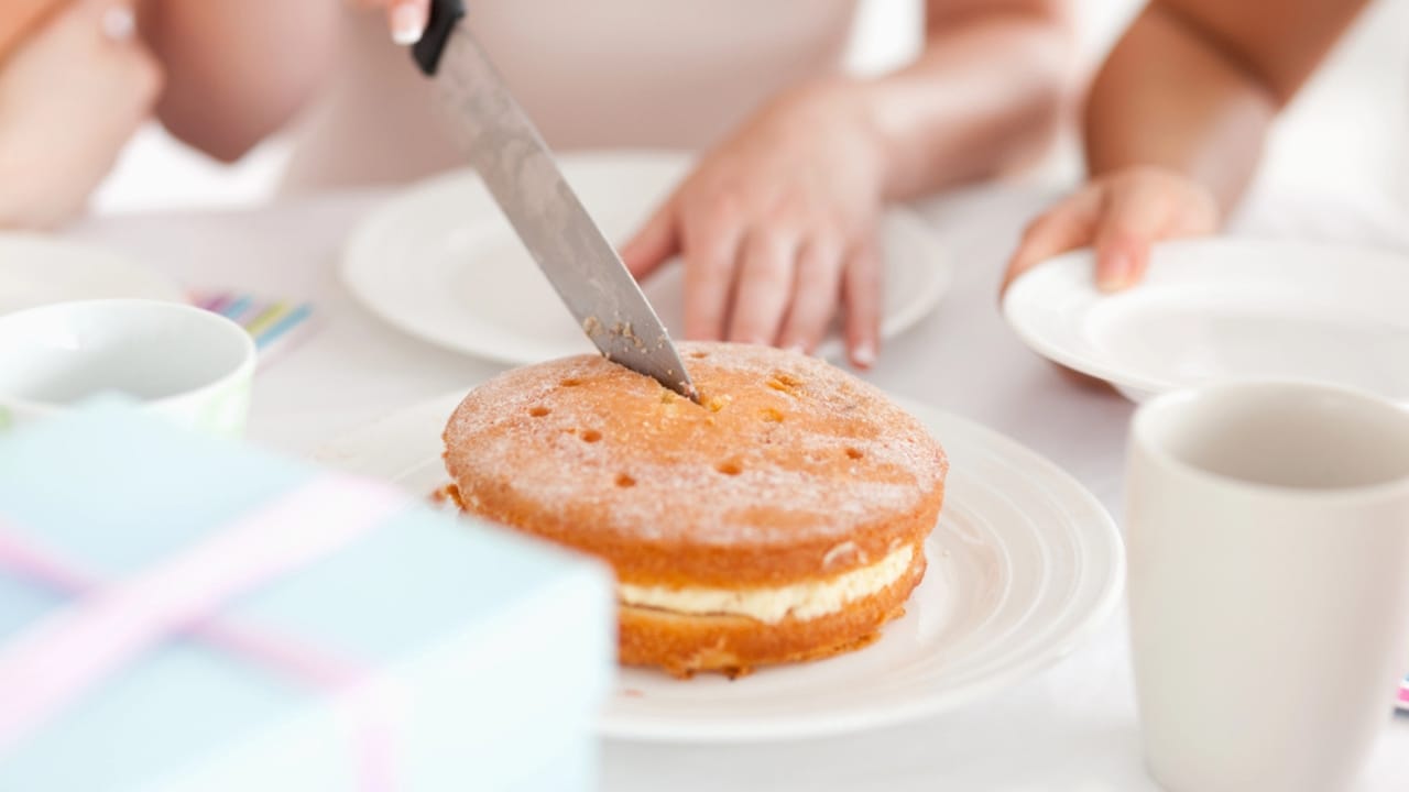 25 Genius Kitchen Tricks for Faster, Cheaper Meals 10 25 Genius Kitchen Tricks for Faster, Cheaper Meals - Woman cutting a cake dp11188807 dnoh